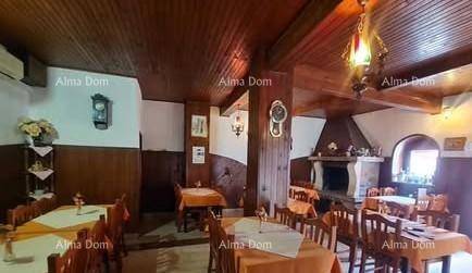Rustikaler Essbereich mit Holztäfelung, Holzbalkendecke und einem traditionellen Kamin.