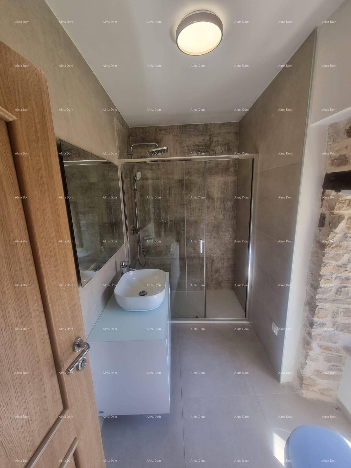 Modernes Badezimmer mit grauen Fliesen, begehbarer Dusche und Einzelwaschbecken.