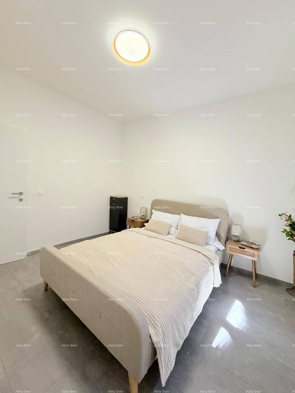 Geräumiges Schlafzimmer mit Doppelbett, minimalistischer Einrichtung und hellem Fliesenboden.