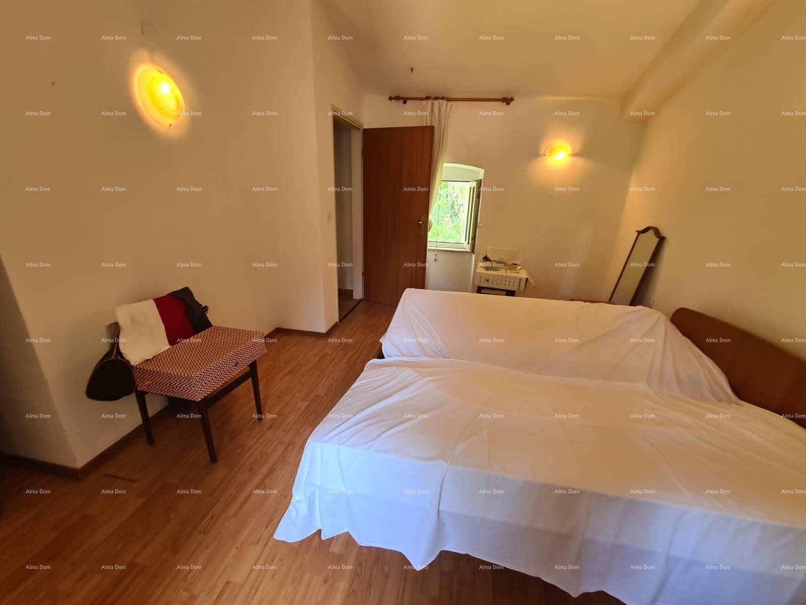 Schlafzimmer mit zwei Betten, kleinem Tisch und Fenster, ausgestattet mit Holzboden.