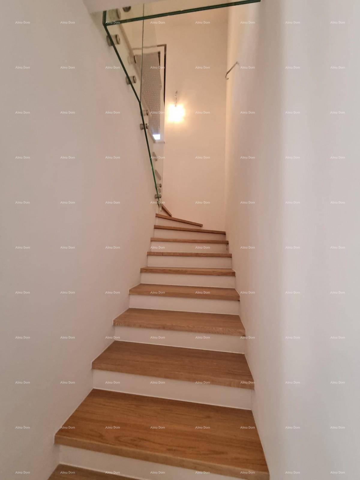 Modernes Treppenhaus mit Holzstufen und Glasgeländer, das die Etagen verbindet.