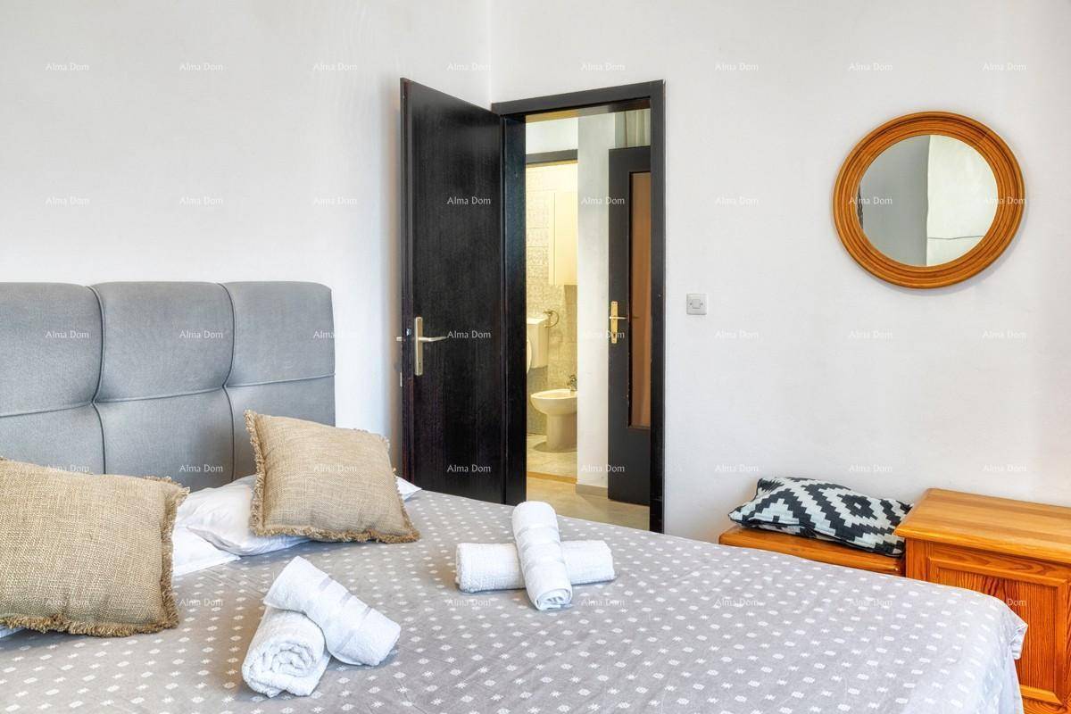 Schlafzimmer mit Doppelbett und Zugang zu einem angrenzenden Badezimmer.