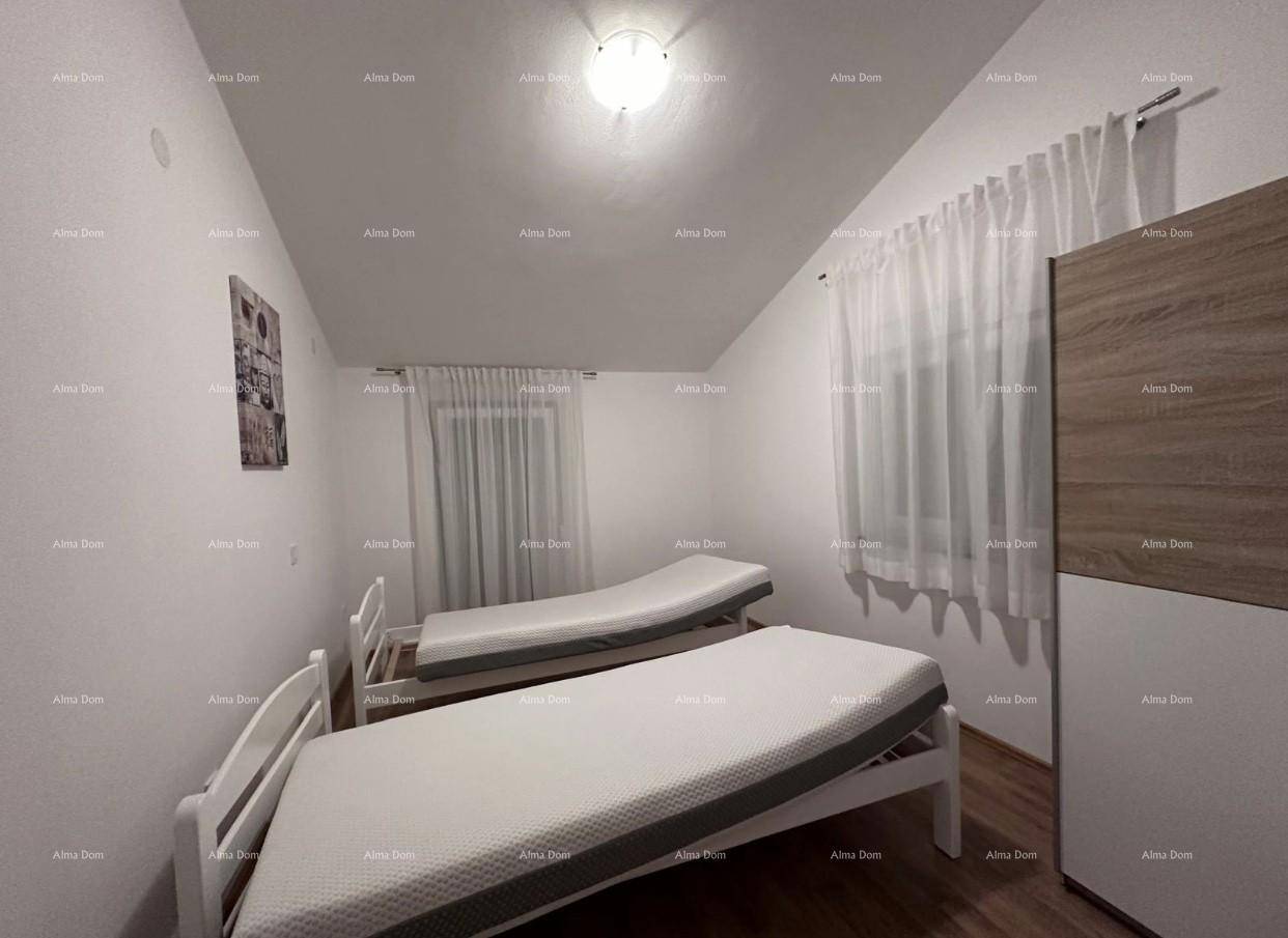 Helles Schlafzimmer im Dachgeschoss mit zwei Einzelbetten und schrägen Decken.