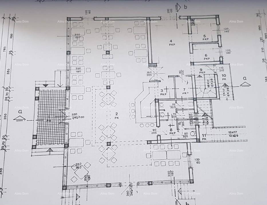 Grundriss eines Geschosses mit großem offenen Bereich, möbliert mit Tischen und Stühlen.
