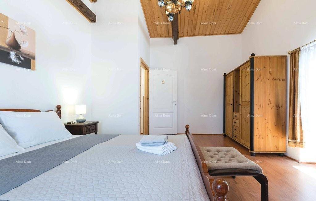 Schlafzimmer mit Holzbalkendecke, Doppelbett und großem Holzschrank.
