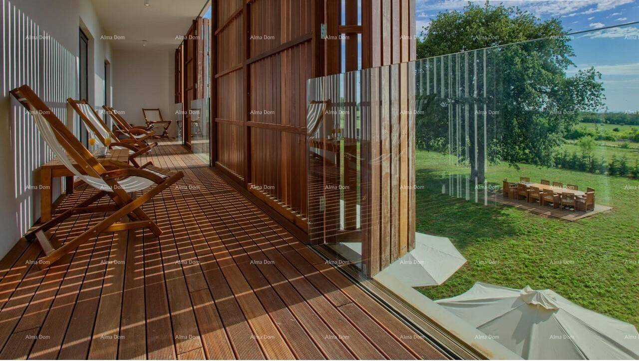 Geräumiger Balkon mit Holzdeck und Liegestühlen, bietet einen weiten Blick auf die Landschaft.