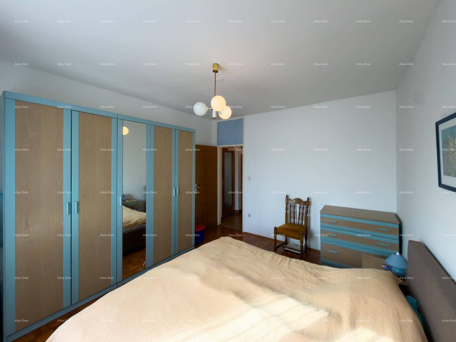 Schlafzimmer mit Doppelbett, Parkettboden und großem Kleiderschrank.