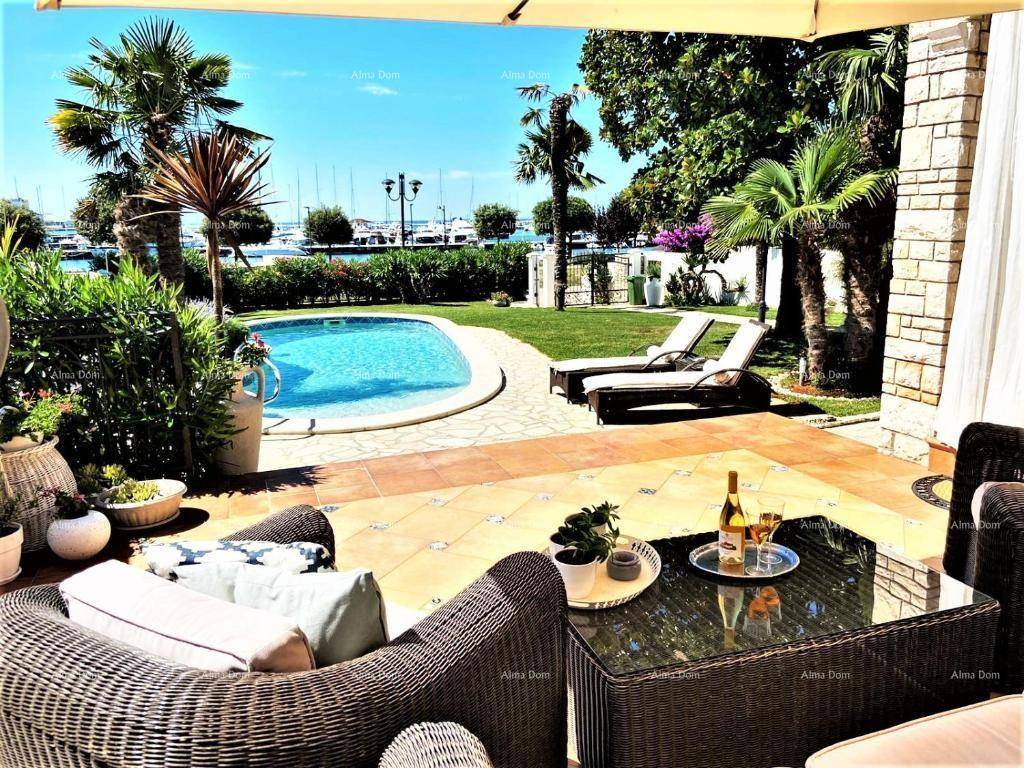 Einladende Terrasse mit Rattanmöbeln, Pool und weitem Blick auf den Yachthafen.