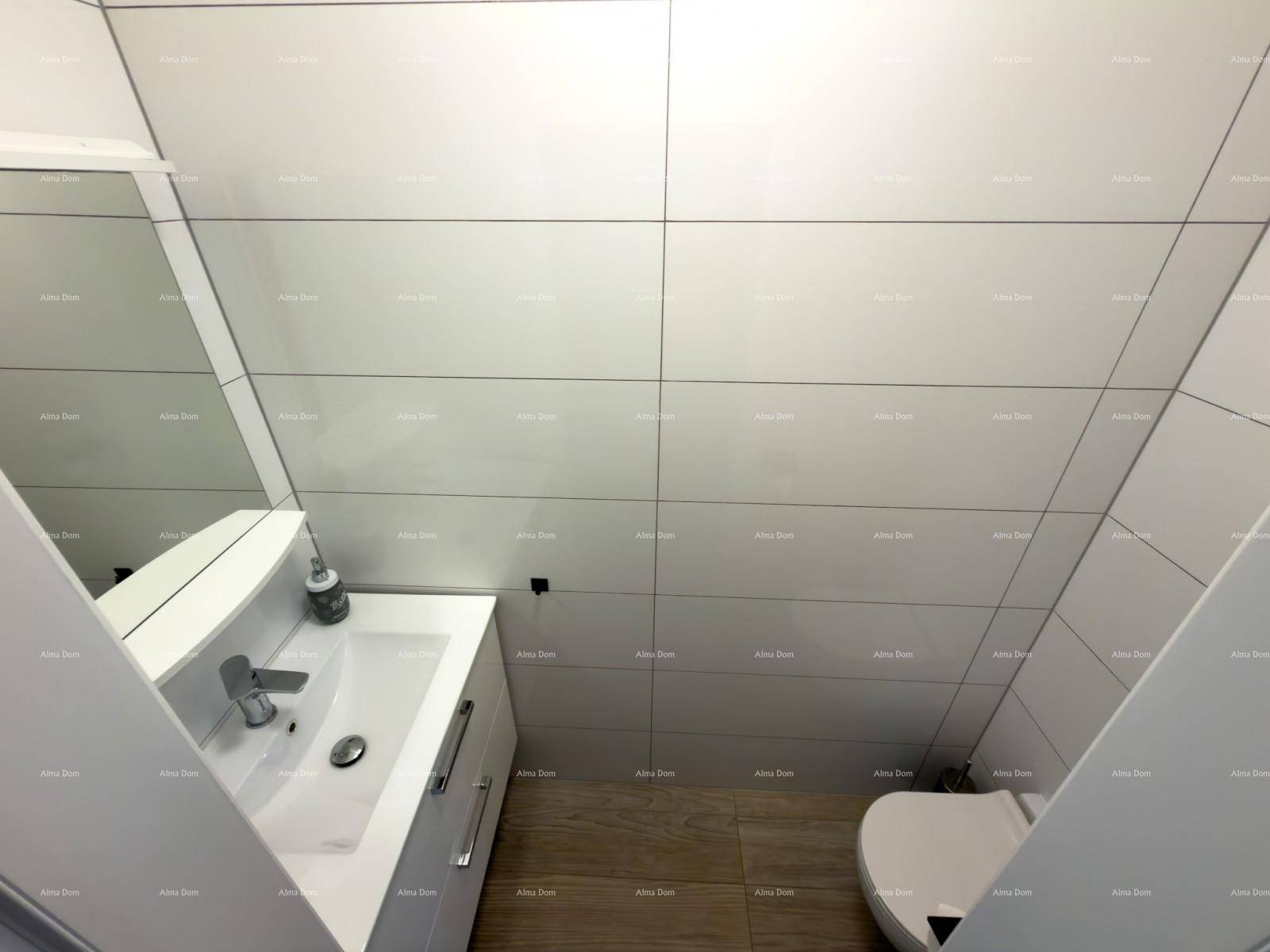 Modernes Gäste-WC mit Wand-WC, Waschbecken und hellen Fliesen.