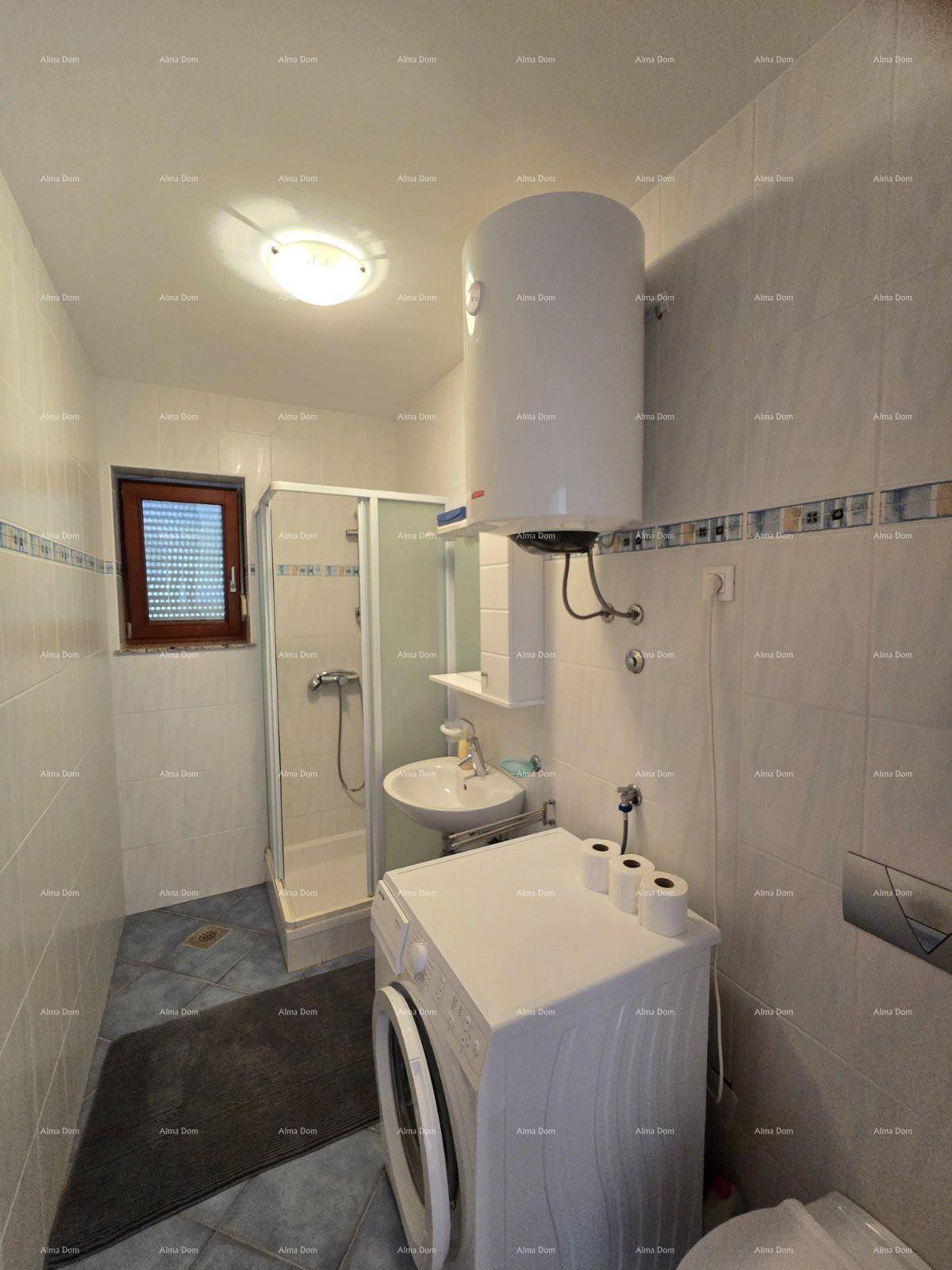 Geräumiges Badezimmer mit Duschkabine, Waschbecken, Waschmaschine und Warmwasserboiler.