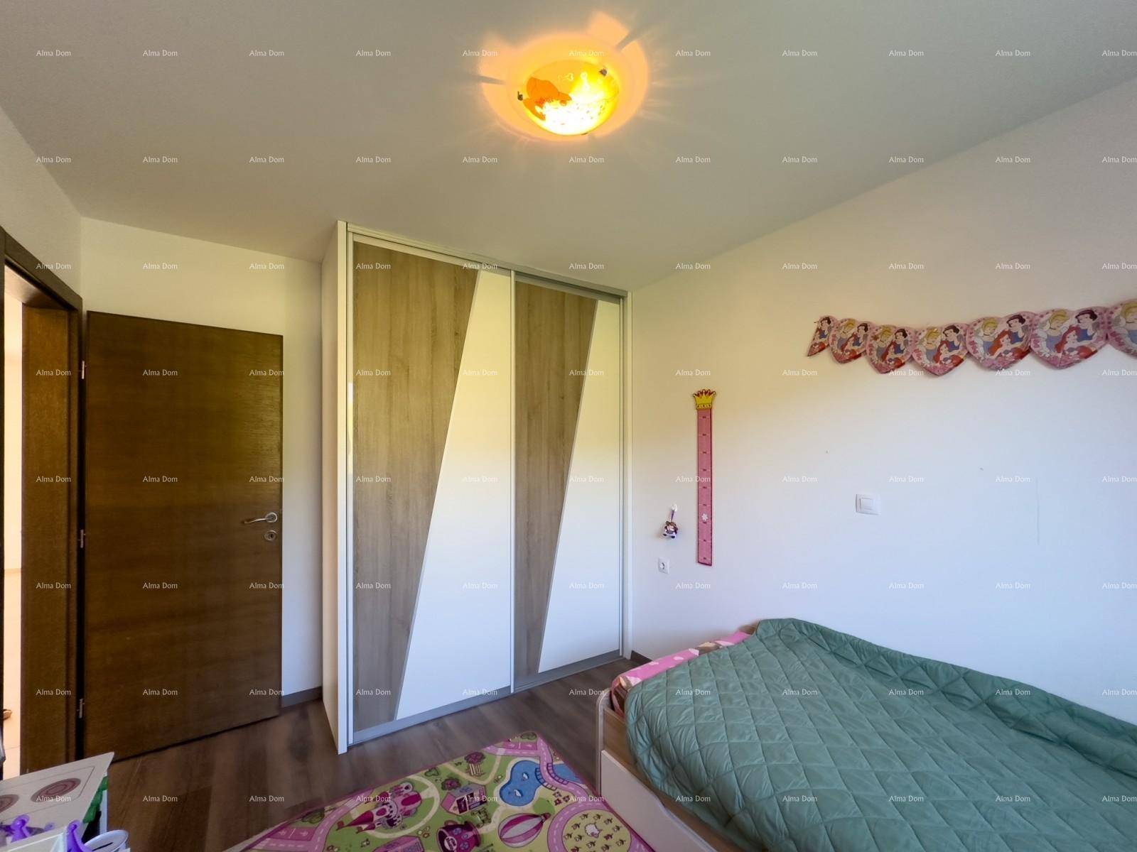 Kinderzimmer mit modernem Kleiderschrank und farbenfrohem Teppichboden.