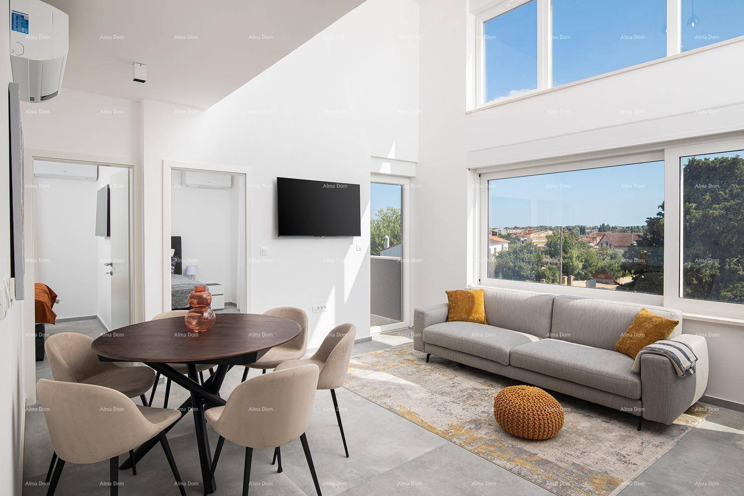 Heller Wohn- und Essbereich mit Fernseher, Esstisch und Zugang zu einem Balkon.