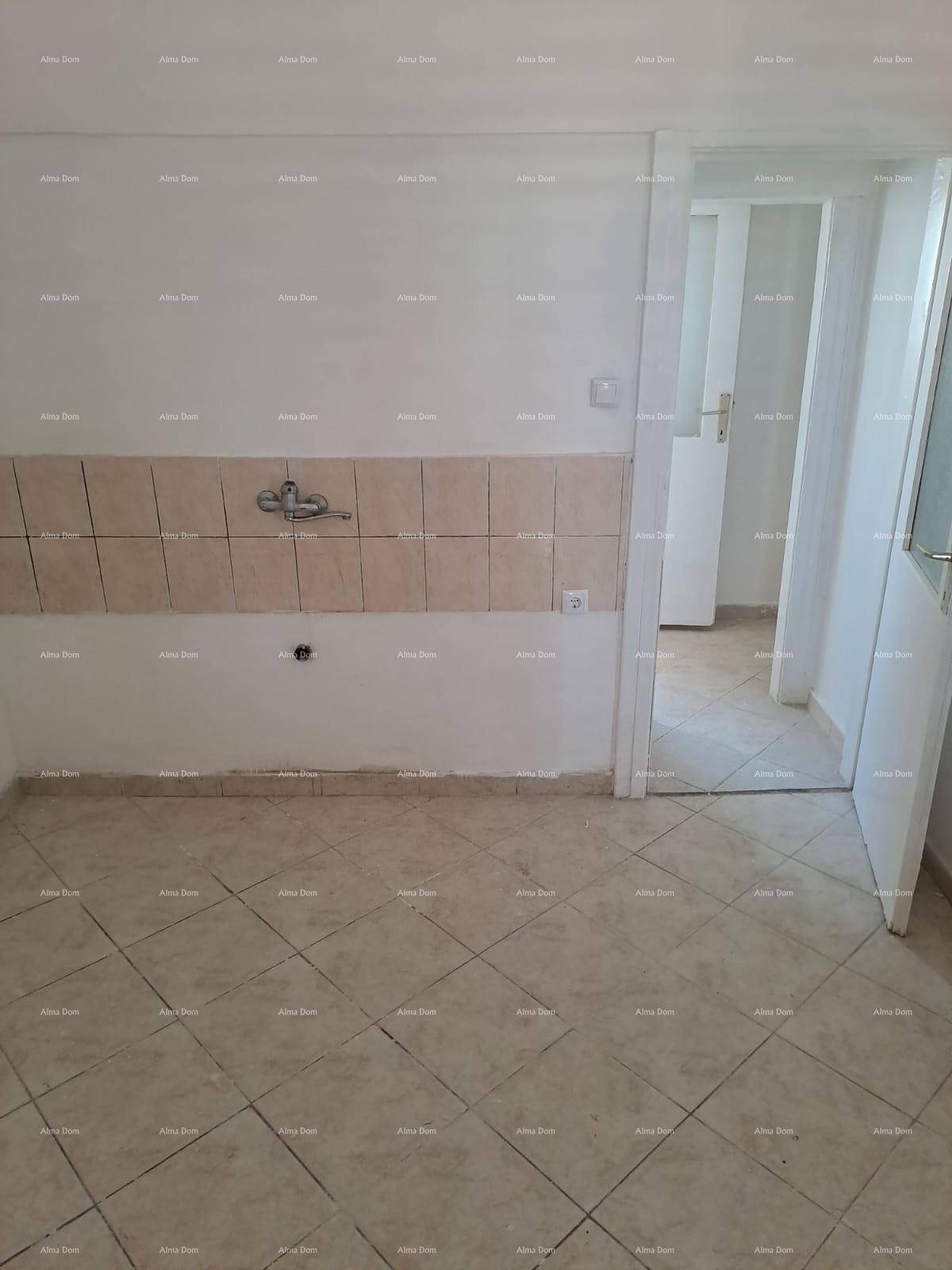 Küchenbereich mit Fliesenboden und gefliestem Spritzschutz, bereit für die Installation einer Küche.