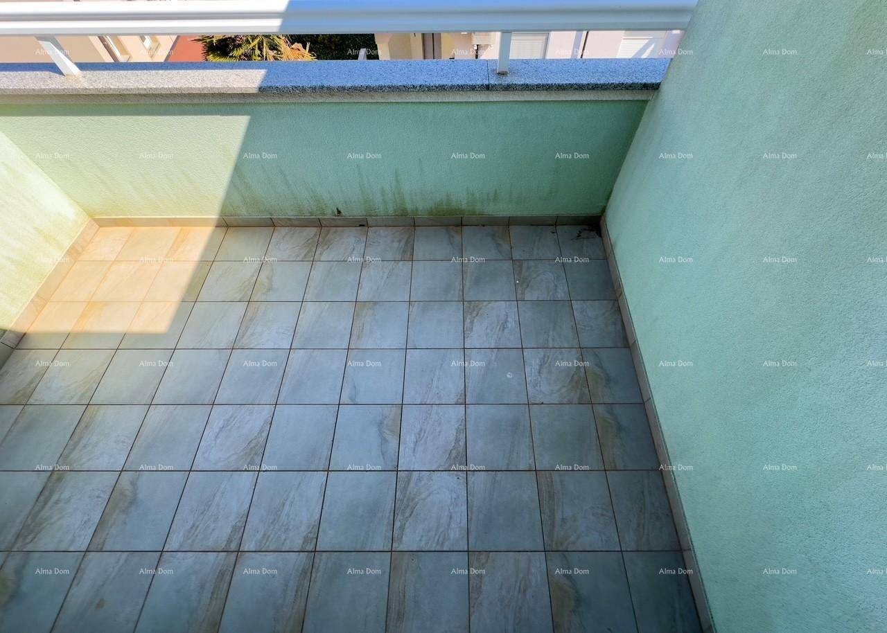 Gefliester Balkon mit hellgrünen Wänden und Blick auf die Umgebung.