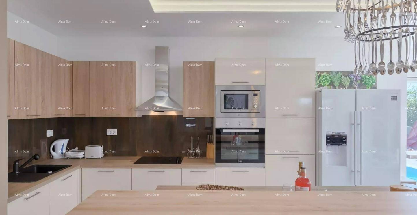 Moderne Einbauküche mit hellen Holzfronten, integrierten Geräten und viel Arbeitsfläche.