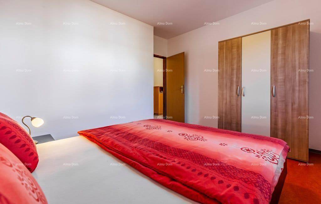Schlafzimmer mit Doppelbett und geräumigem Kleiderschrank in Holzoptik.