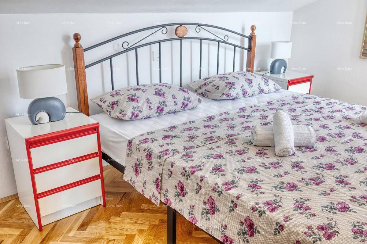 Schlafzimmer im Dachgeschoss mit Doppelbett, Nachttischen und floraler Bettwäsche.