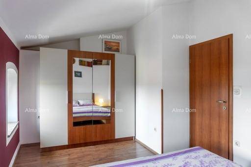 Schlafzimmer mit großem Spiegelschrank und Holzboden, bietet Stauraum und eine helle Atmosphäre.