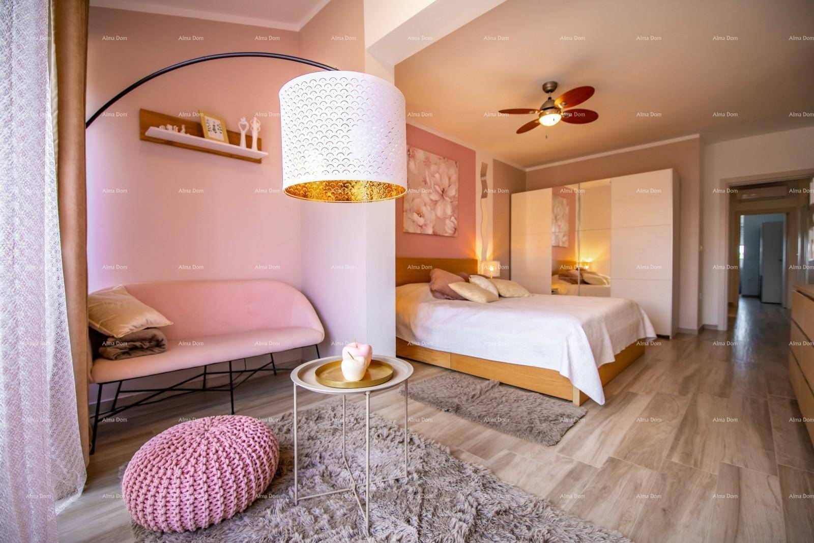 Komfortables Schlafzimmer mit Doppelbett, Deckenventilator und separater Sitzecke.