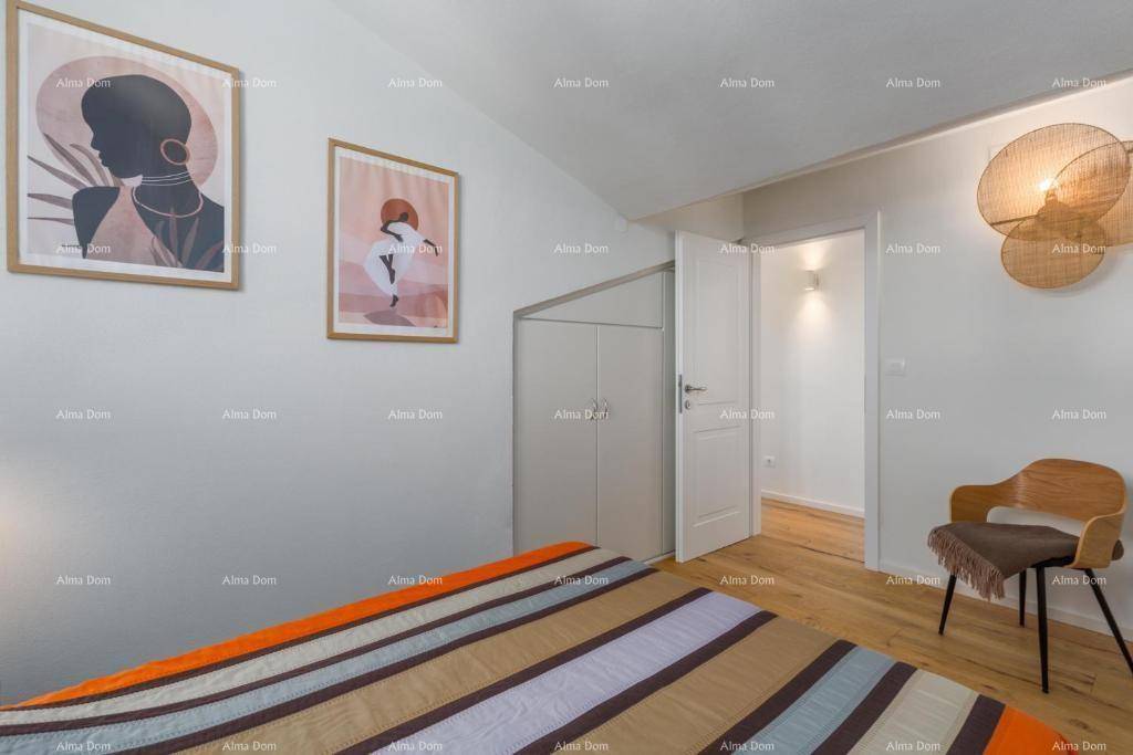 Schlafzimmer mit Holzboden, moderner Kunst an den Wänden und Zugang zu einem weiteren Raum.