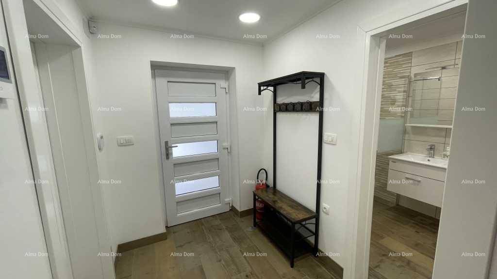 Heller Eingangsbereich mit Garderobe und Zugang zu einem Badezimmer und weiteren Räumen.