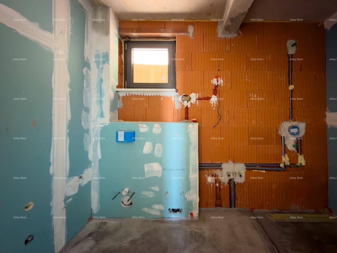 Unfertiges Badezimmer mit sichtbaren Sanitärinstallationen, Ziegelwänden und einem kleinen Fenster.