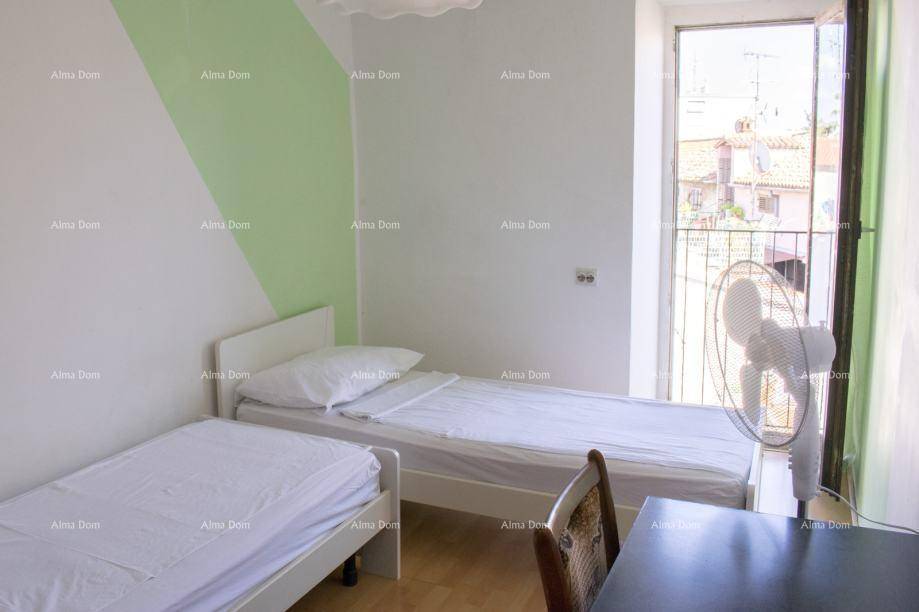 Helles Schlafzimmer mit zwei Einzelbetten und Zugang zu einem französischen Balkon.