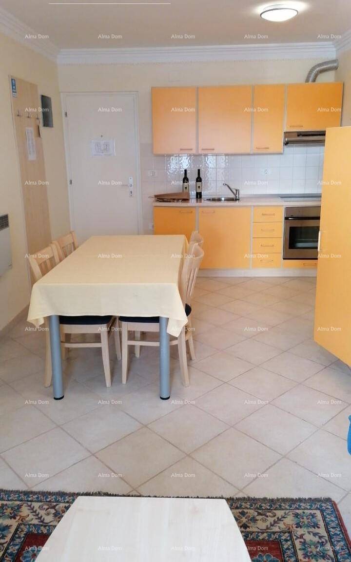 Funktionale Küche mit orangefarbenen Schränken und Essbereich, gefliestem Boden.