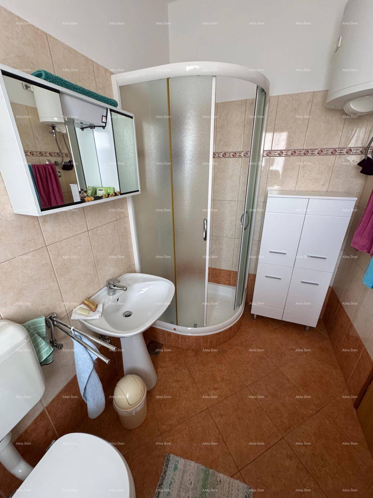 Badezimmer mit Duschkabine, Waschbecken und Toilette, mit Spiegelschrank.