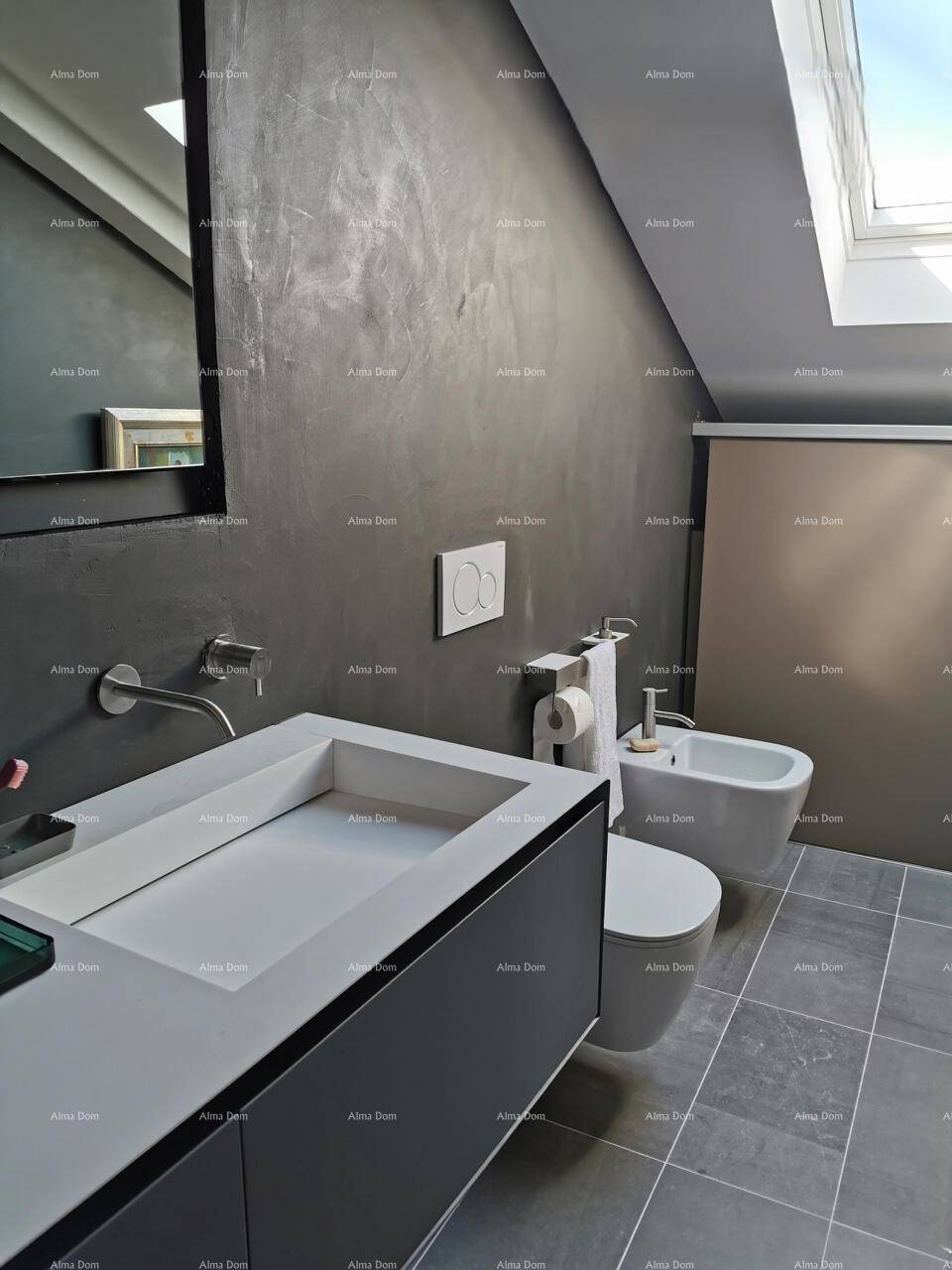 Stilvolles Badezimmer mit modernem Waschtisch, Bidet und Wand-WC unter einer Dachschräge.