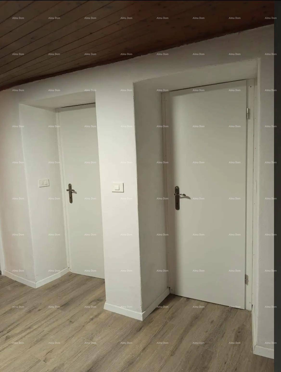 Heller Flur mit zwei weißen Türen und Holzbalkendecke.