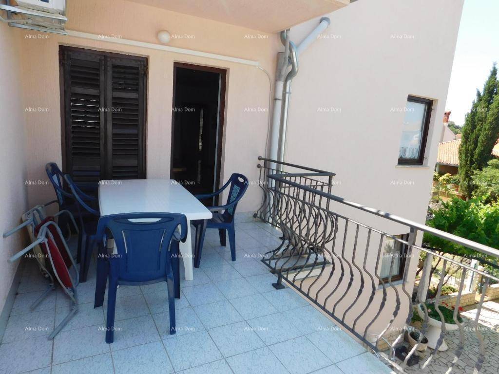 Balkon mit Gartenmöbeln, Fliesenboden und schmiedeeisernem Geländer.