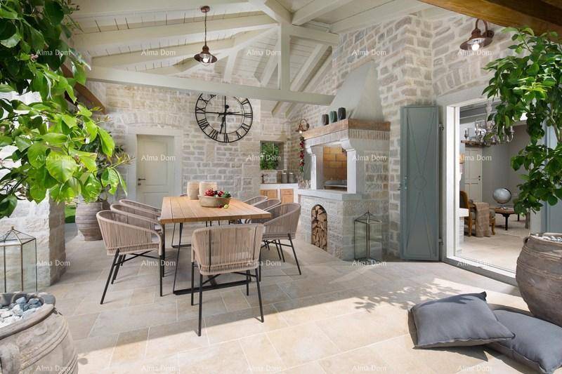 Überdachte Terrasse mit Essbereich, Außenküche und gemauertem Grill für gesellige Abende.