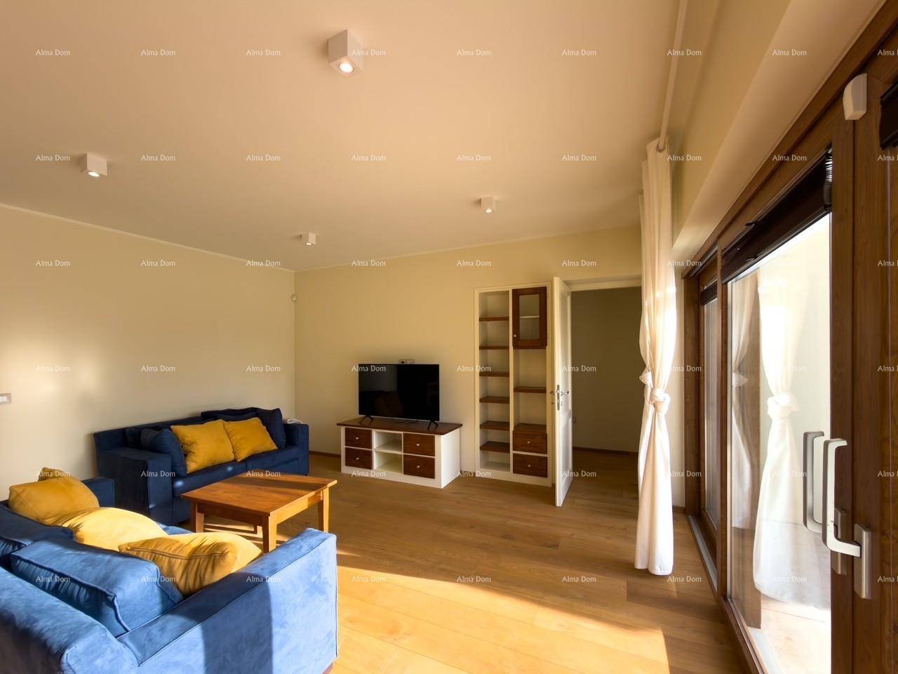 Gemütliches Wohnzimmer mit blauen Sofas, Holztisch und Zugang zur Terrasse durch große Glastüren.
