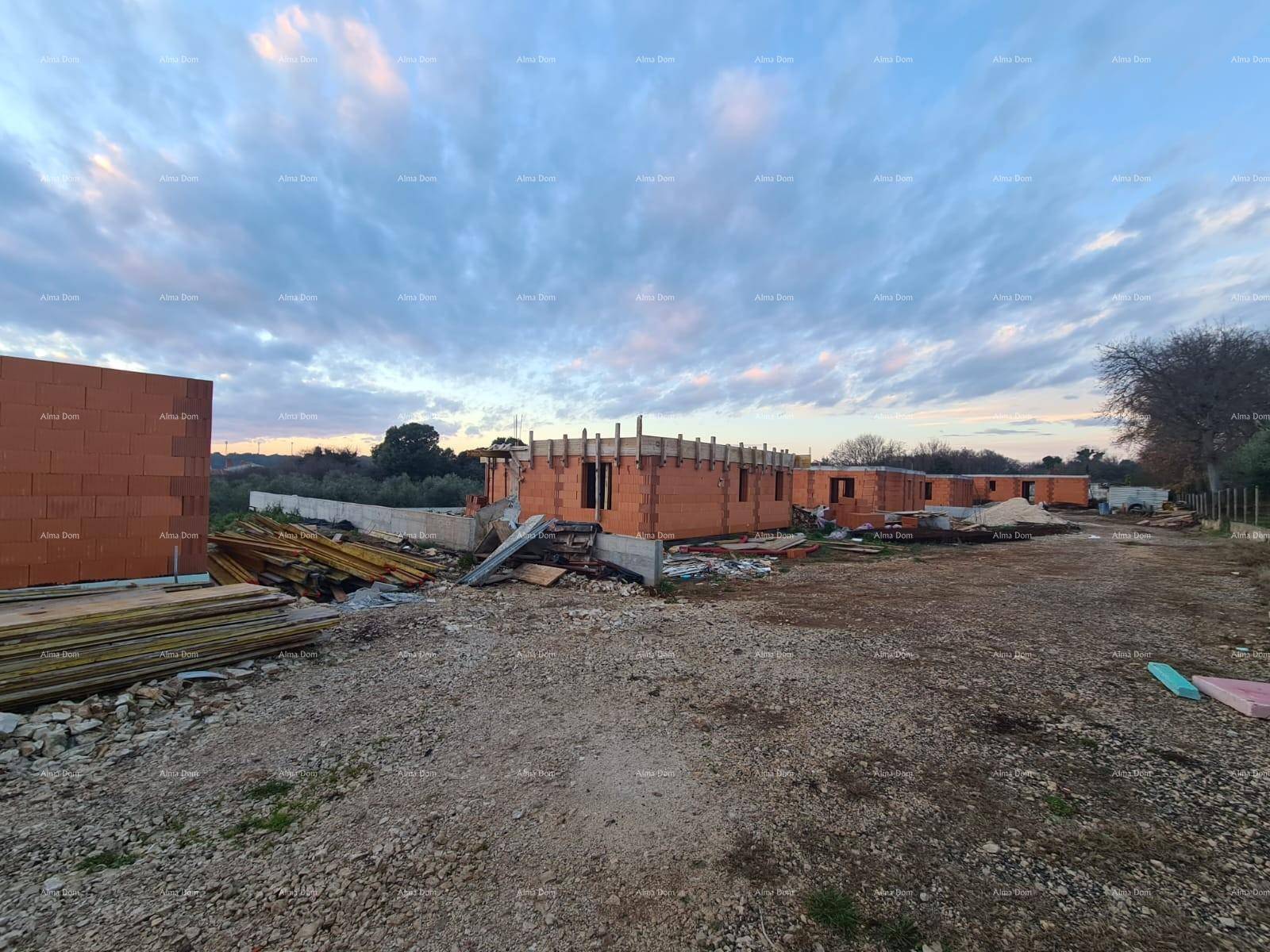 Weitläufige Baustelle mit mehreren im Bau befindlichen Gebäuden und Baumaterialien im Freien.