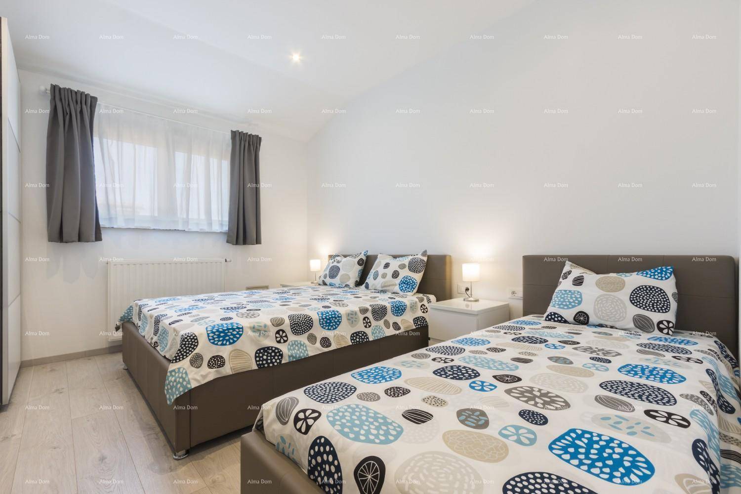 Helles Schlafzimmer mit zwei Einzelbetten, farbenfroher Bettwäsche und einem Fenster.