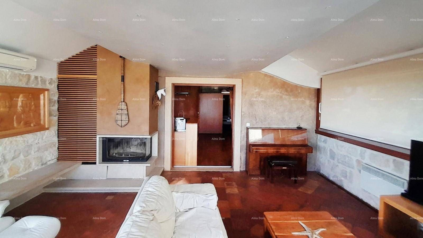 Gemütliches Wohnzimmer mit Kamin, Klavier und traditionellen Steinwänden.