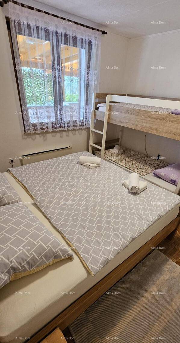 Helles Schlafzimmer mit Doppelbett, Etagenbett und Blick ins Grüne.