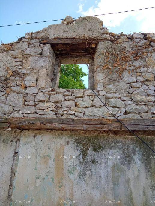 Detailansicht einer verfallenen Steinmauer mit einer leeren Fensteröffnung und Holzbalken.