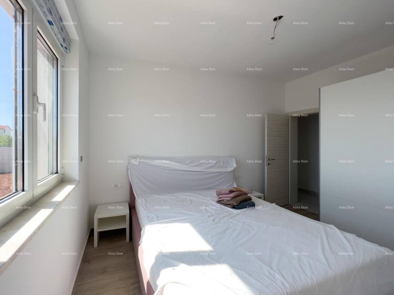 Helles Schlafzimmer mit großem Fenster, Nachttisch und viel Tageslicht.