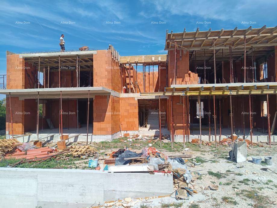 Baustelle eines modernen Gebäudes mit sichtbaren Ziegelwänden und vorbereiteten Deckenstrukturen.