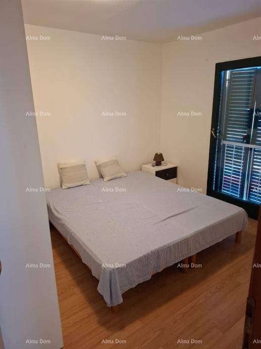 Schlafzimmer mit Doppelbett, Nachttisch und Fenster mit grünen Fensterläden für Privatsphäre.