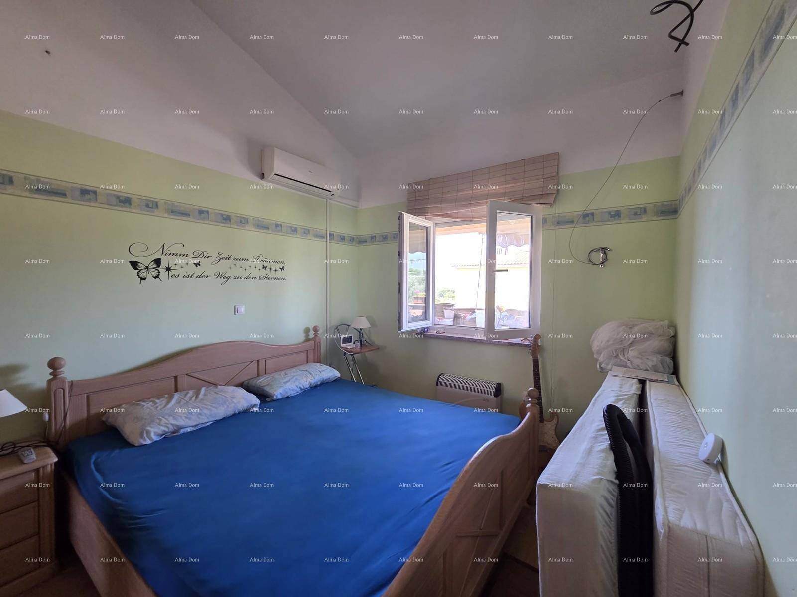 Schlafzimmer mit Doppelbett, grünen Wänden, Klimaanlage und Fenster mit Blick nach draußen.