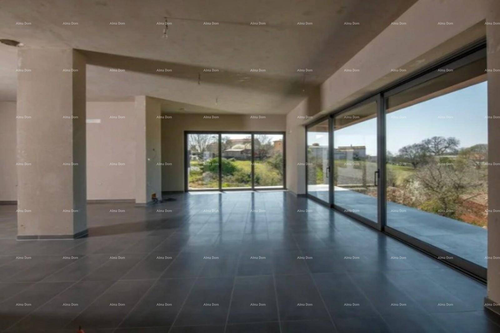 Heller Wohnraum im Rohbau mit großen Glasfronten, die viel Tageslicht hereinlassen und Ausblick bieten.
