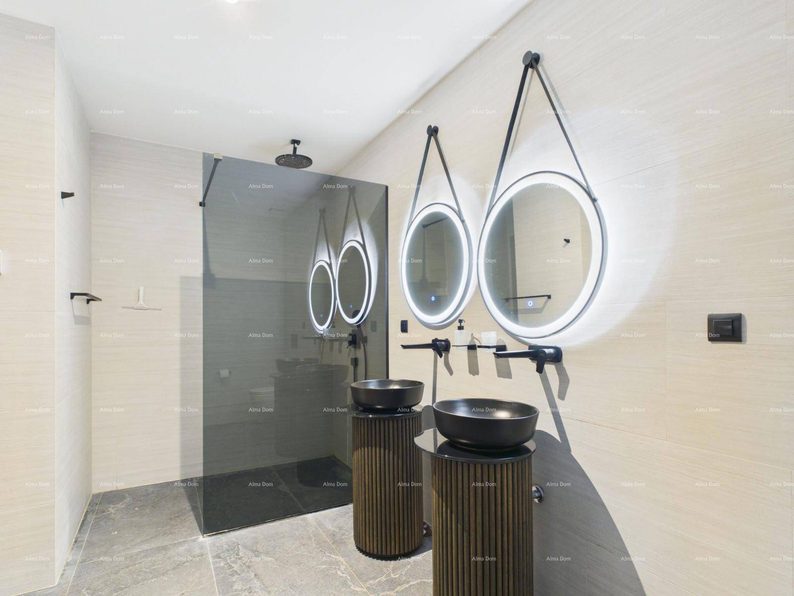 Modernes Badezimmer mit zwei Waschbecken, beleuchteten Spiegeln und einer begehbaren Dusche.