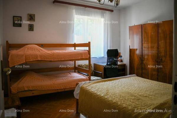 Schlafzimmer mit Etagenbett, Einzelbett und einem großen Kleiderschrank aus Holz.