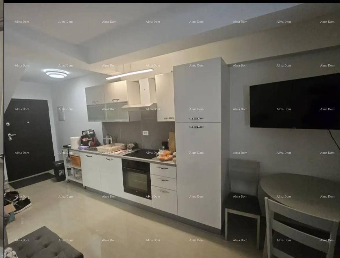 Kompakte Küche mit weißen Schränken, integriertem Backofen und kleinem Essbereich.