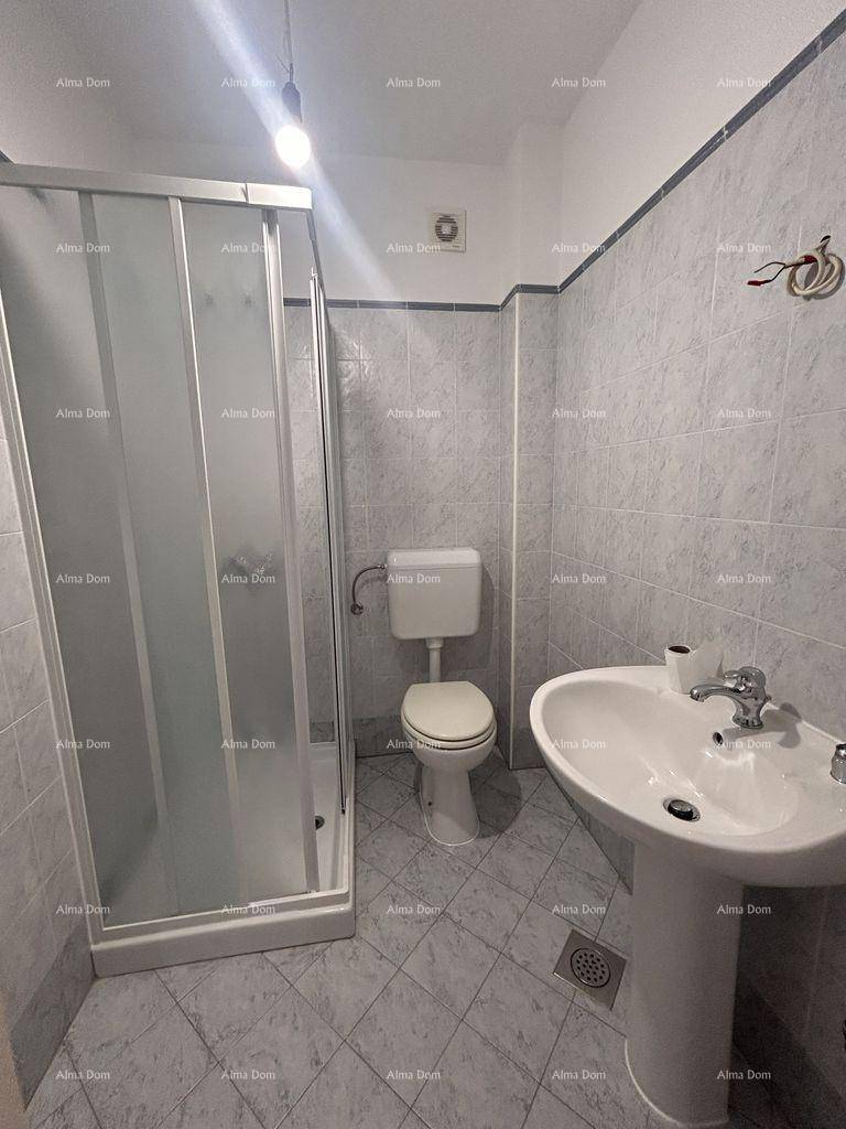 Funktionales Badezimmer mit Duschkabine, WC und Waschbecken, komplett gefliest in hellen Tönen.