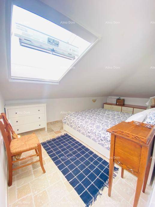 Helles Schlafzimmer mit großem Dachfenster, Doppelbett und Kommode unter der Dachschräge.
