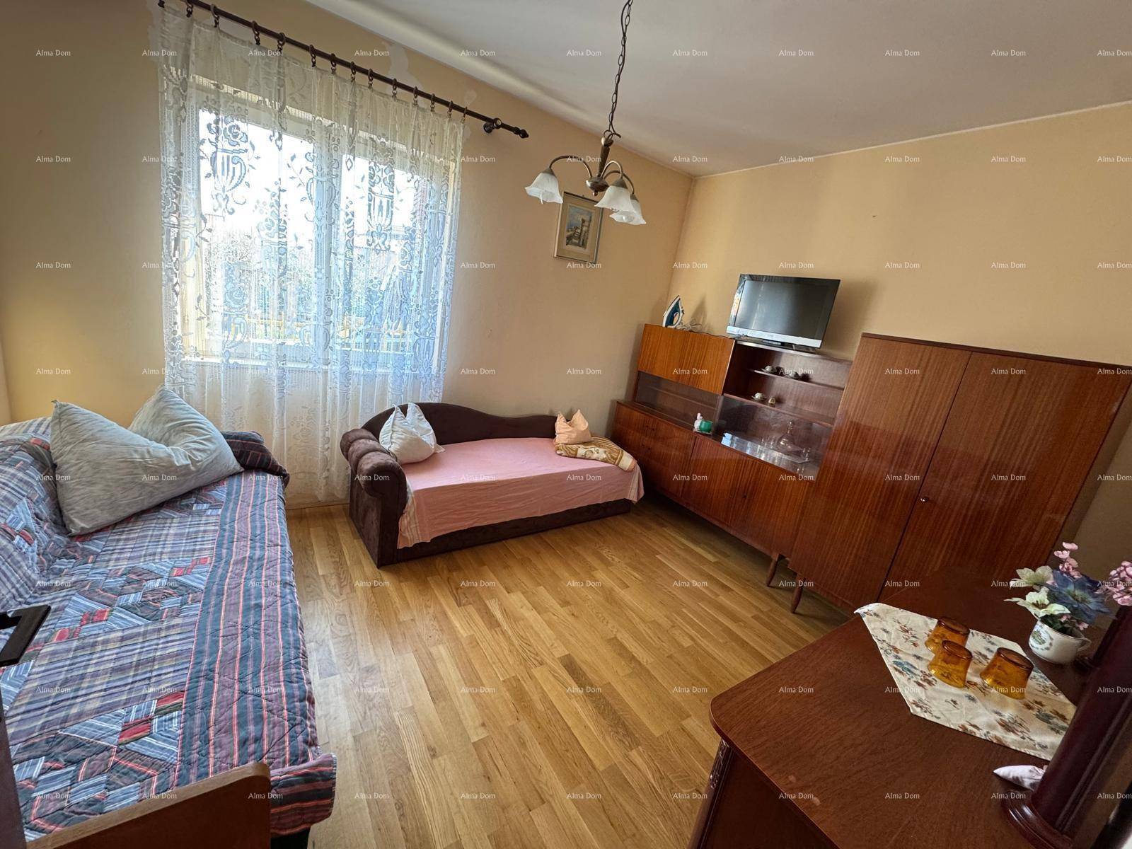 Schlafzimmer mit Tagesbett, Holzschrank und Parkettboden, mit viel Tageslicht.